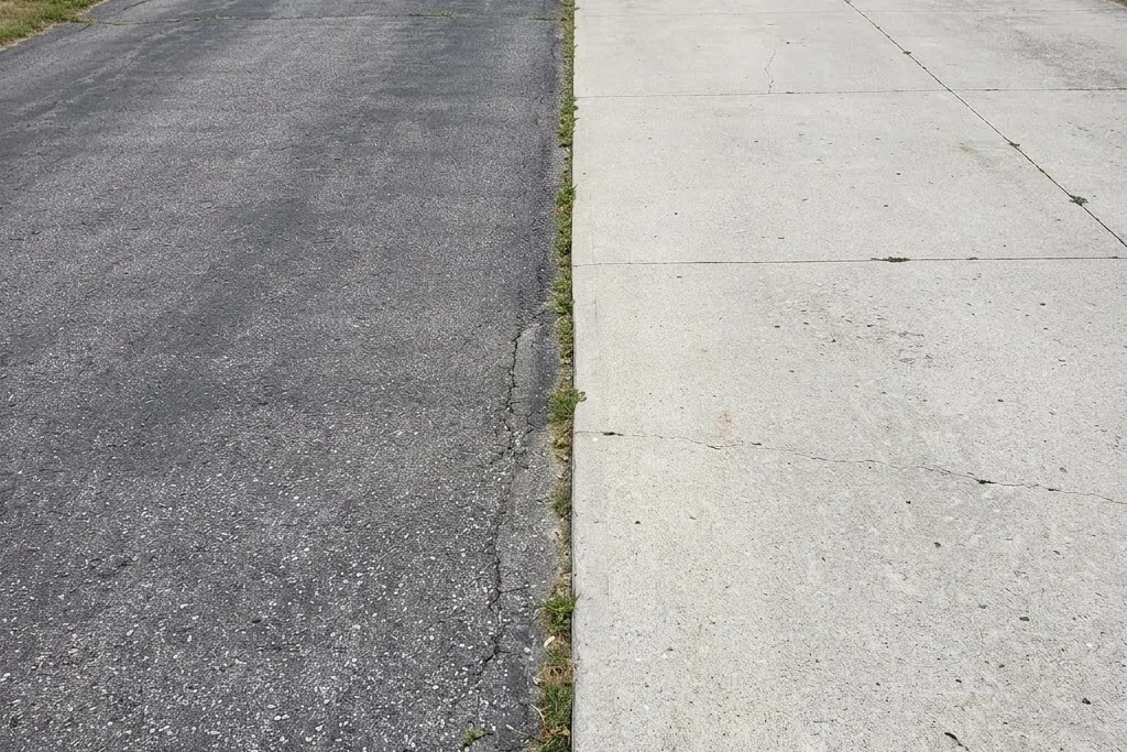 An asphalt driveway beside a concrete one for comparison